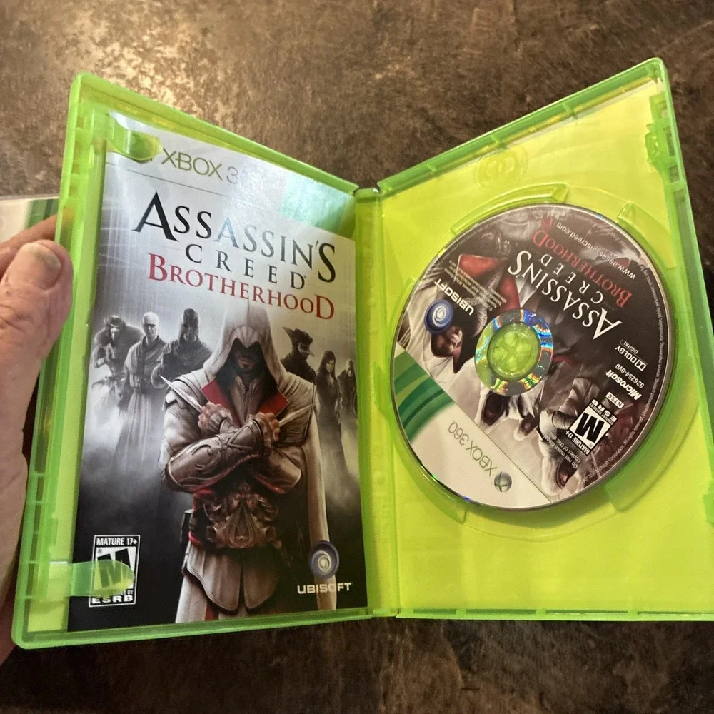 Three Xbox 360 Games, Assassin Creed, Battlefield, And Call Of Duty